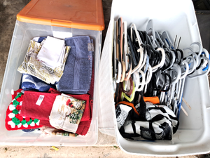 lot 195 image: Storage tote full of kitchen textiles and laundry basket full of hangers plus