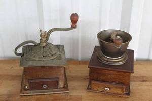 lot 4 image: Two vintage manual coffee grinder  featuring a wooden box base and one has a decorative cast iron top mechanism.