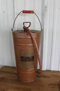 lot 27 image: antique copper and brass hand pump fire extinguisher, often referred to as a pump tank or fire guard type, dating back to the mid-20th century.