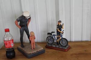 lot 39 image: vintage Daniel Monfort original sculpture titled Policeman and Child 1980 and Vanmark Blue Hats of Bravery Police Officer figurine titled Park Duty.