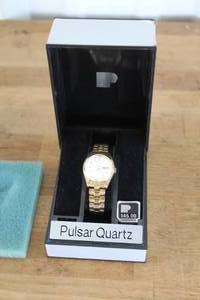 lot 60 image: Pulsar Quartz watch is a mens timepiece featuring a gold-toned bezel, case, and stainless steel bracelet