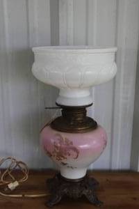 lot 159 image: Victorian-style lamp featuring a hand-painted floral design on a pink and white glass base with a matching milk glass top globe.