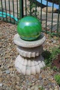 lot 474 image: green glass gazing globe on a traditional pedestal stand.