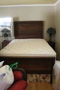 lot 518 image: solid dark wood bed frame with a carved headboard