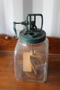 lot 605 image: antique Dazey butter churn is a vintage kitchen tool with a square glass jar and a hand-crank mechanism.