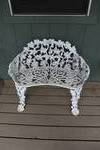 Victorian-style white cast iron garden bench featuring a grape vine and leaf pattern