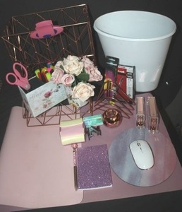 lot 127 image: Desk set up in Pink, includes mouse pads, white wireless mouse, pink metal paper holders, pen holders, stapler, tape dispenser, pens faux roses and white trashcan, paperclip holder and pink paperclips and pink staples