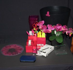 lot 132 image: Desk Set up in fuchsia, black trashcan, fuchsia tape dispenser and stapler, pen holders and plastic vases, new pens, variety of pens and highlighters Scissors and mouse pad, faux flowers