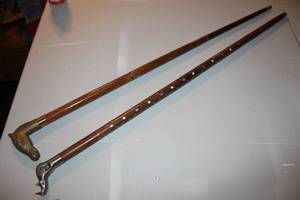 lot 102 image: brass horse-headed walking cane. And  a handcrafted walking cane with a rhinoceros head handle made of nickel or pewter