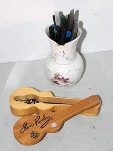 lot 118 image: Elvis Presley E.P.E. official ballpoint pen in a wooden guitar-shaped case.and vase full of pens