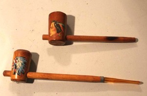 lot 137 image: vintage wooden souvenir peace pipes featuring painted imagery of a Native American chief