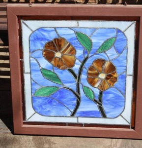 lot 282 image: vintage handmade stained glass floral panel featuring amber flowers with green leaves on a blue background about 23x24