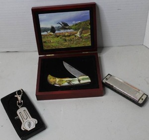 lot 329 image: Franklin Mint collectible pocket knife housed in a wood display box & Cadillac emblem golf ball marker and divot tool keychain &  a Hohner Pocket Pal harmonica