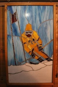 lot 412 image: hand-cut stained glass panel depicting a skier in a yellow outfit about 21x35