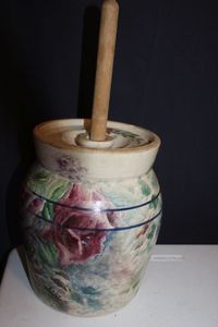 lot 161 image: Vintage stoneware butter churn with a floral pattern and wooden dasher.