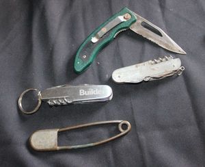 lot 217 image: Three pocket knives and vintage safety pin
