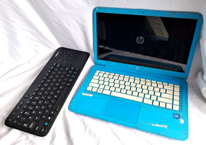 lot 110 image: HP Stream laptop model 14-ax010wm (powers on) plus Logitech keyboard