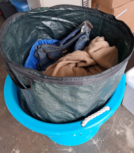 lot 99 image: Large tub & collapsible clothing hamper full of purses