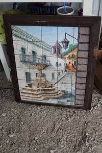 lot 54 image: decorative framed panel made of tiles depicting a town scene with a fountain.