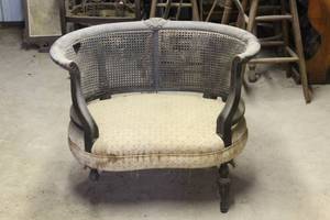 lot 219 image: vintage French-style settee features a distinctive curved wooden frame and intricately patterned cane back detailing front lag broken