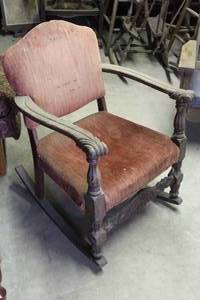 lot 221 image: antique Victorian-style rocking chair features carved wooden arms and faded, patterned fabric upholstery