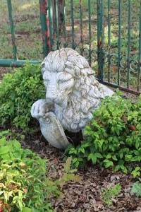stone garden statue of a lion holding a shield