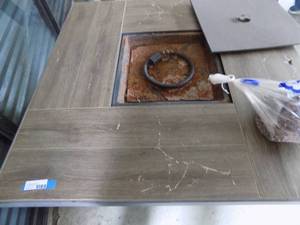 lot 79 image: Fire Pit 4x4 propane tile top cracked comes with burner cover and lava stones no tank