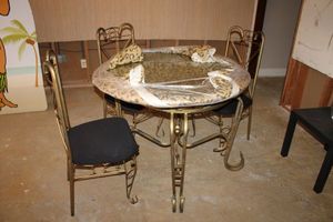 lot 110 image: Glass top dining table with 3 chairs (glass is wrapped for moving)