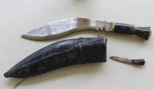 lot 76 image: Vintage Kukri knife with traditional leather or wood-covered scabbard, includes smaller utility blade (karda or chakmak)