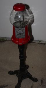 Vintage Gumball Machine bank with red metal base and cast-iron stand