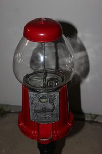 Vintage Gumball Machine bank with red metal base and cast-iron stand