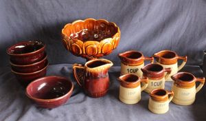 lot 148 image: Hull Pottery brown drip glaze, serving bowl, Measuring cups, creamer pitcher and bowls
