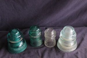 lot 156 image: Four Vintage glass telephone wire insulators