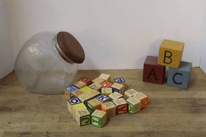 lot 114 image: vintage glass slant-front canister jar and wooden alphabet block set