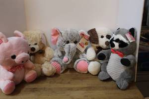 lot 129 image: collection of plush toys including a pink pig, a teddy bear, an elephant, and a raccoon most have there tags