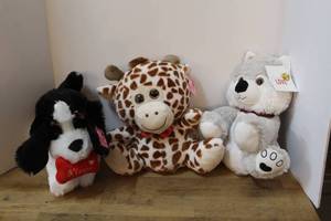 lot 130 image: three stuffed animal plush toys a black and white dog, a giraffe with prominent brown spots, and a white arctic animal all have there tags