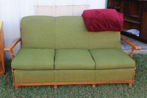 vintage Mid-Century Modern sofa features a green-gold textured fabric, a structured three-cushion design, and a light-colored wooden frame with angular arms