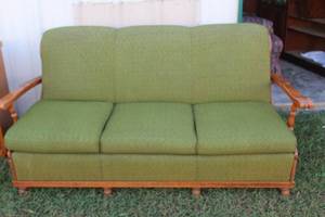 vintage Mid-Century Modern sofa features a green-gold textured fabric, a structured three-cushion design, and a light-colored wooden frame with angular arms