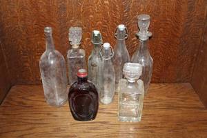 lot 356 image: collection features a variety of vintage clear and dark glass bottles and decanters, including swing-top bail wire bottles