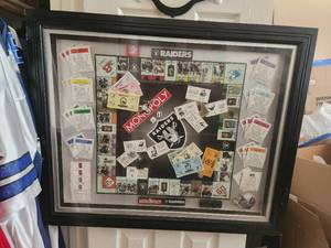 lot 182 image: Framed and under glass NFL Raiders Monopoly set - 1 piece is loose - 28 x 34