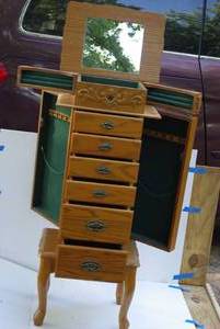 Traditional standing jewelry armoire with decorative carved scrollwork