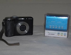 lot 105 image: Nikon Coolpix and mini speaker new in box- camera tested and working (see pics - battery latch held with tape)