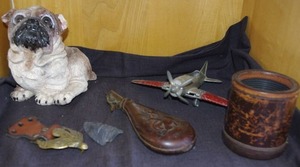 lot 242 image: Vintage items featuringHubley Kiddie Toy airplane, classic critter pug, vintage brass belt buckle, arrowhead, Antique leather and brass black powder flask, and yahtzee cup