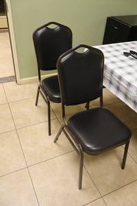 lot 51 image: Black vinyl stackable banquet chairs - set of 4