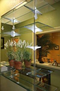lot 160 image: Glass shelves with metal brackets and artificial plants (not the mirror on the wall)