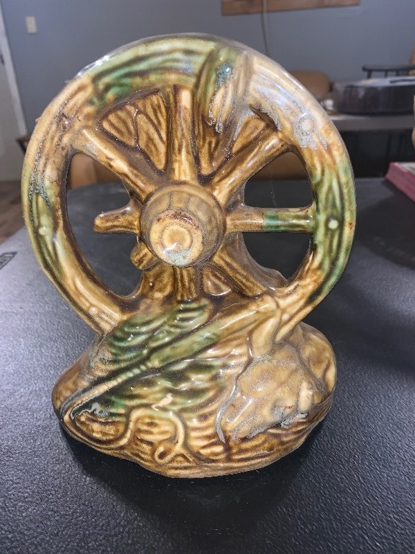 lot 52 image: VINTAGE CERAMIC COVERED WAGON WHEEL & bull skull  WESTERN VASE   McCoy Nice vintage ceramic Western-themed decorative planter or vase featuring a large covered wagon wheel with bull skull design. Looks like McCoy
