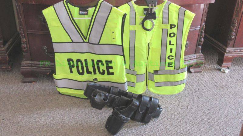 lot 96 image: Authentic Safariland Police utility belt with pistol holster, ASP model 200 hinged handcuffs and safety vests