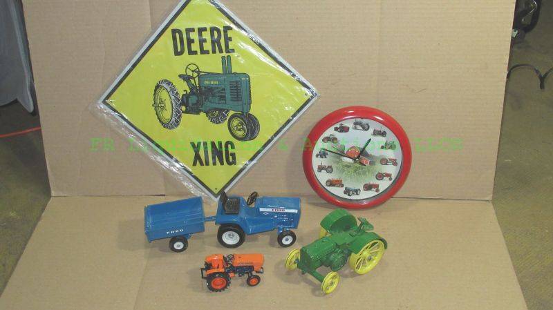 lot 104 image: Die cast toy tractor collection including John Deere (plus tin sign), Ertyl Ford with wagon and Kubota, also includes Tractor theme wall clock