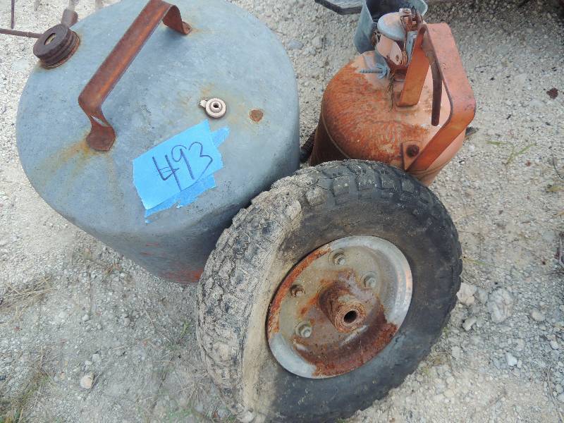 lot 493 image: 2 vintage metal  gas cans and 1 old riding mower tire