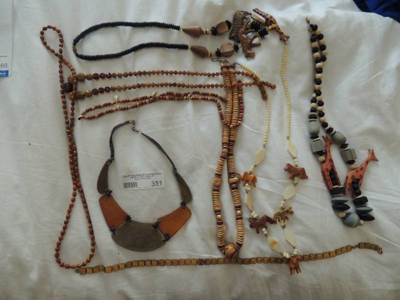 lot 351 image: Jewelry-  8 piece african inspired wood,  gold and amber necklaces. Some with carved animal